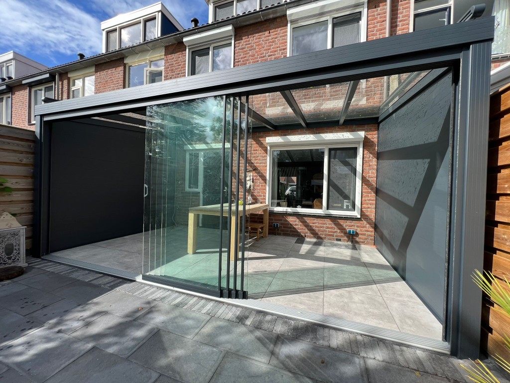 Referenz Bayern: Aluminium-Terrassenüberdachung in Anthrazit mit Glasschiebewänden und integrierter Markise am Landhaus