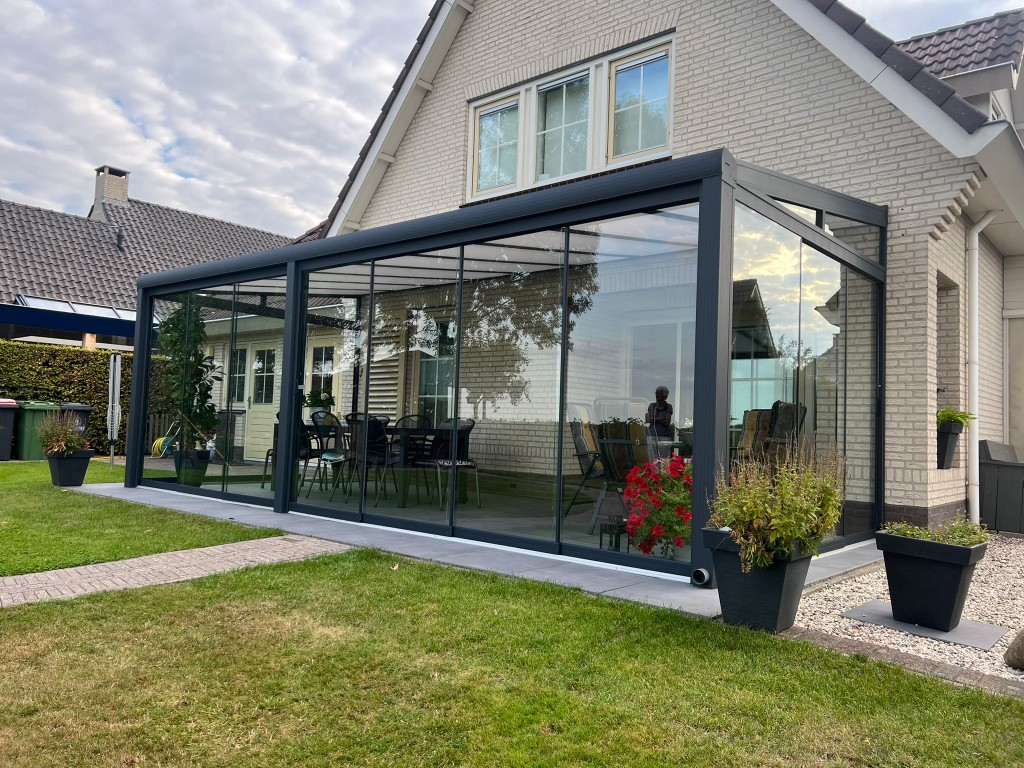 Referenz Berlin: Eckanordnung der Aluminium-Terrassenüberdachung in Anthrazit mit Glasschiebewänden am Reiheneckhaus