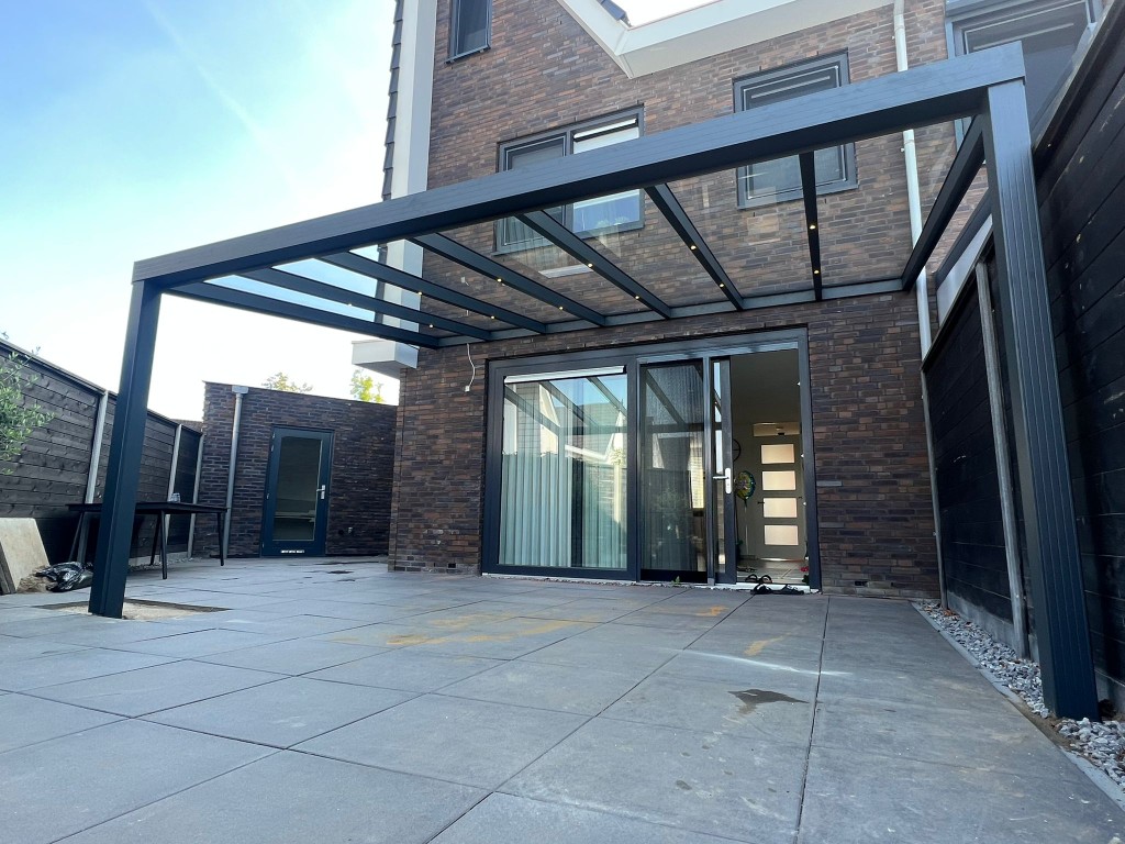 Referenz Niedersachsen: Schrägdach-Terrassenüberdachung aus Aluminium in Anthrazit mit Glas-Eindeckung und integrierter LED-Beleuchtung an einer Doppelhaushälfte