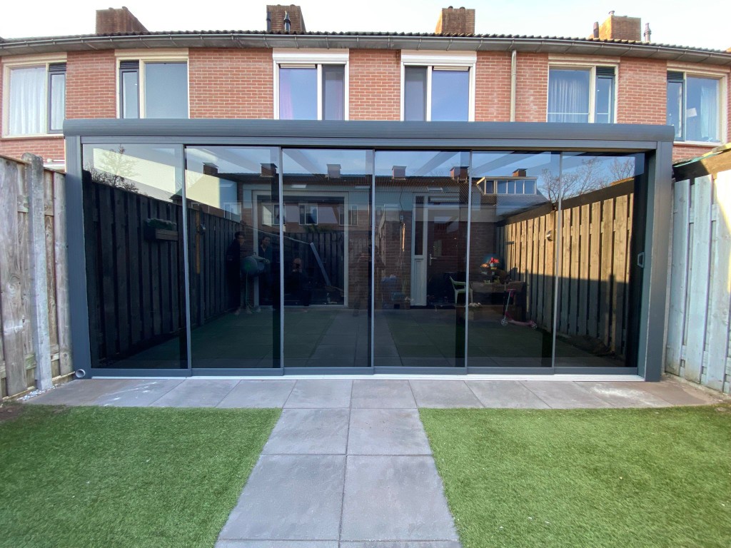Referenz Ruhrgebiet: Cubo-Flachdach-Terrassenüberdachung aus Aluminium in Anthrazit mit Glasschiebewänden an einem Reihenhaus
