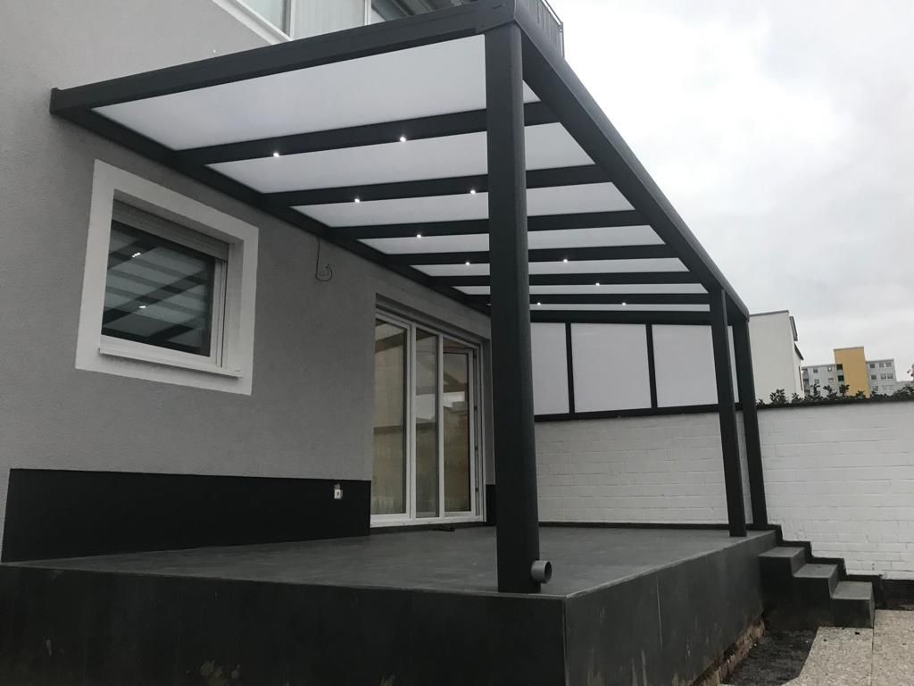 Referenz Schleswig-Holstein: Großflächige Aluminium-Terrassenüberdachung in Anthrazit mit klarer Eindeckung und integrierter LED-Beleuchtung an einem Neubau
